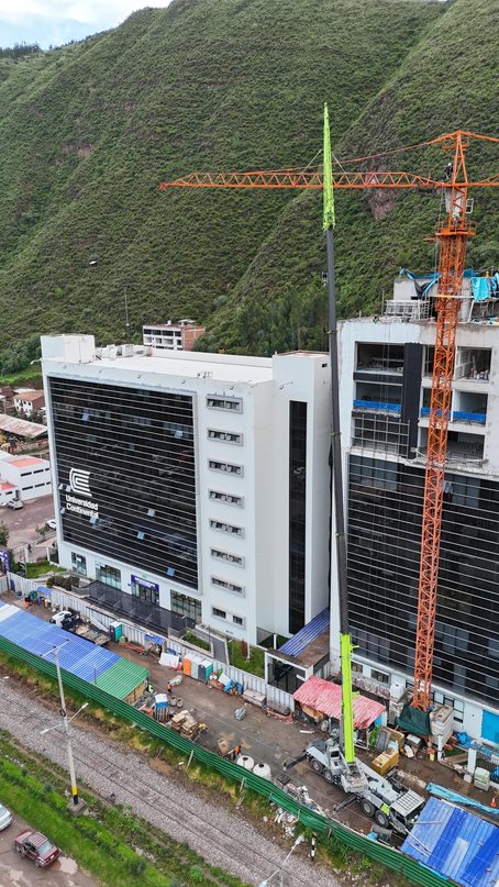 Grúa torre de gran altura junto a un edificio de varios pisos